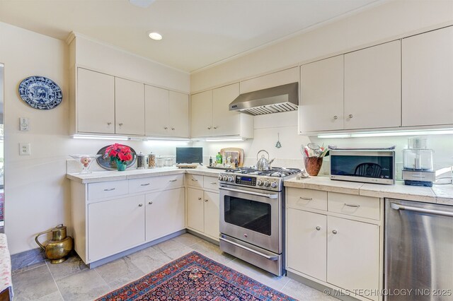 kitchen featuring wall chimney range hood and appliances with stainless steel finishes