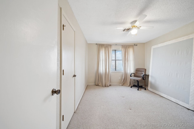 bedroom featuring ceiling fan, light colored carpet, and a textured ceiling