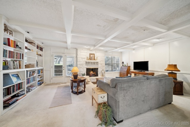 carpeted living room with beam ceiling, a fireplace, a healthy amount of sunlight, and coffered ceiling