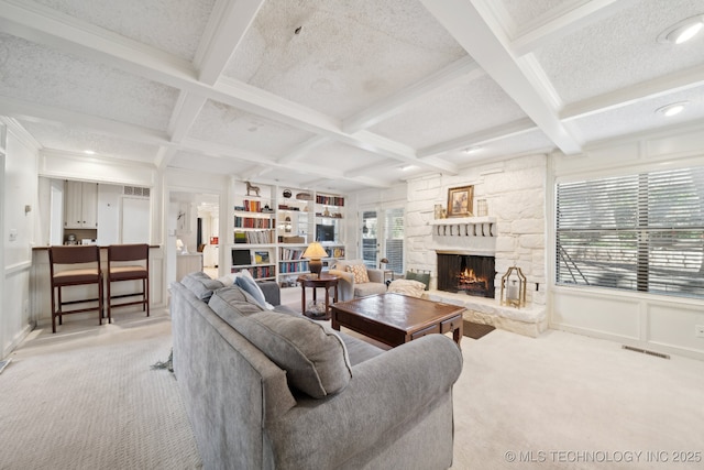 carpeted living room with a textured ceiling, beam ceiling, a fireplace, and coffered ceiling