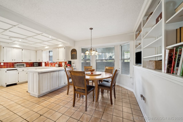 tiled dining area featuring a textured ceiling and an inviting chandelier