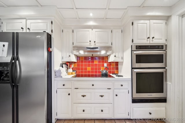 kitchen with white cabinets, appliances with stainless steel finishes, tasteful backsplash, and coffered ceiling