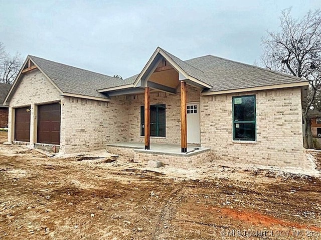 unfinished property featuring a porch and a garage