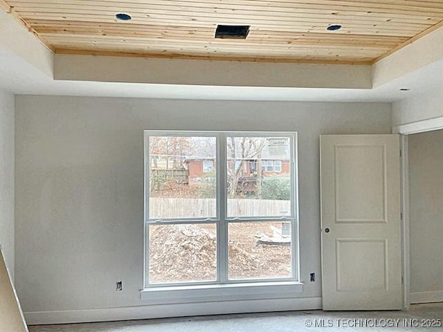 interior space with a raised ceiling and wooden ceiling