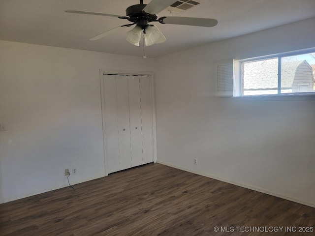 unfurnished bedroom featuring ceiling fan, a closet, and dark hardwood / wood-style floors