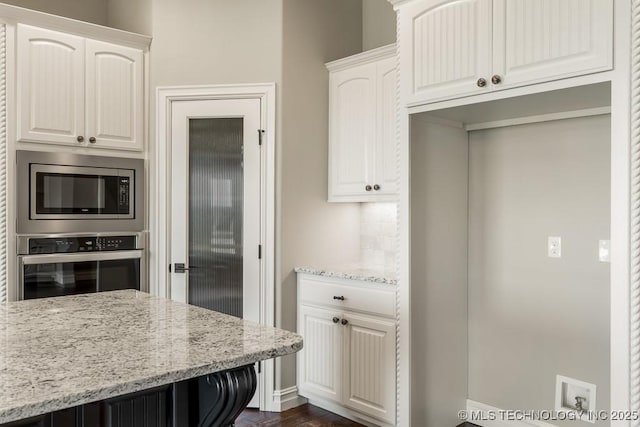 kitchen featuring light stone countertops, appliances with stainless steel finishes, and white cabinetry