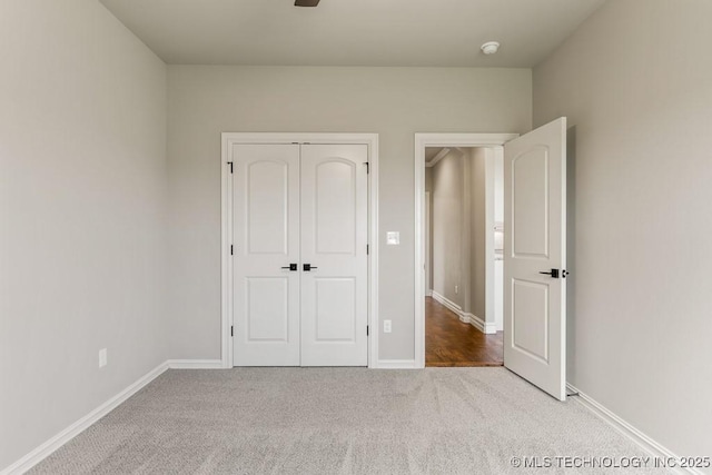 unfurnished bedroom with light colored carpet and a closet