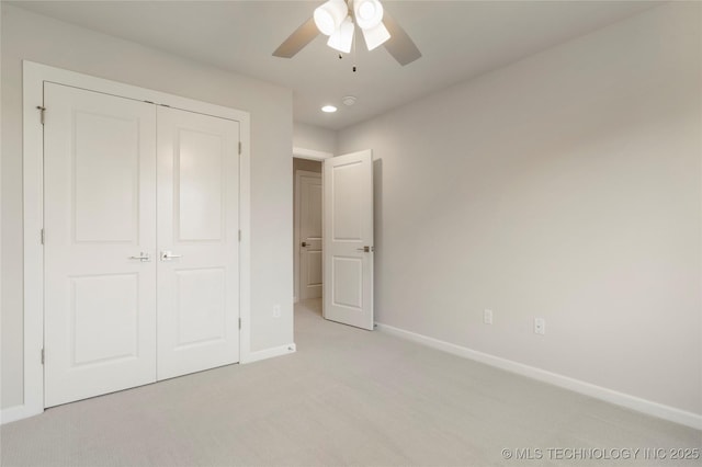 unfurnished bedroom with light colored carpet, a closet, and ceiling fan