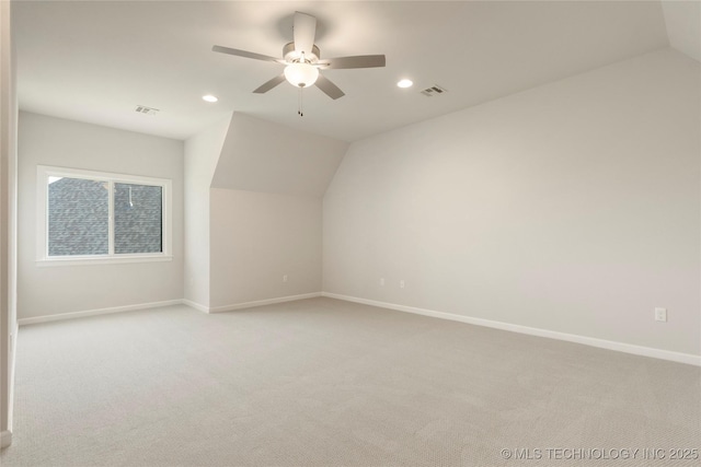 additional living space featuring ceiling fan, light colored carpet, and vaulted ceiling