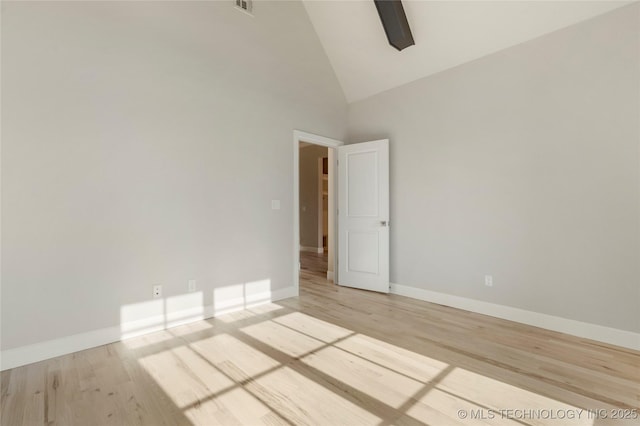 unfurnished room with light hardwood / wood-style flooring and high vaulted ceiling