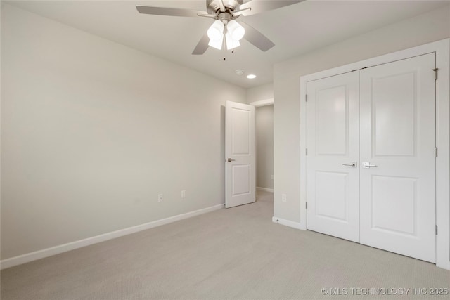 unfurnished bedroom with ceiling fan, light carpet, and a closet