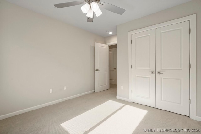 unfurnished bedroom featuring light colored carpet, a closet, and ceiling fan