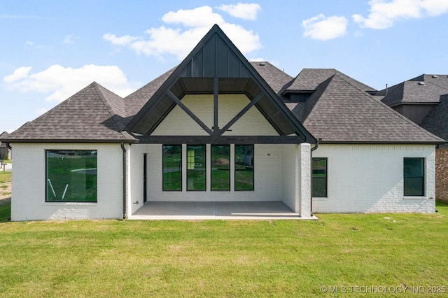 back of property with a lawn and a patio