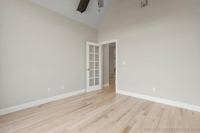 spare room featuring ceiling fan, french doors, high vaulted ceiling, and light wood-type flooring