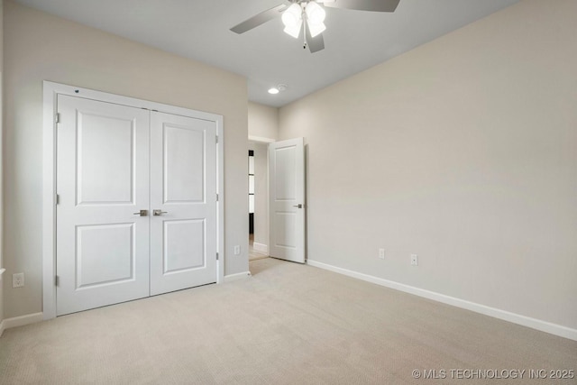 unfurnished bedroom featuring ceiling fan, light colored carpet, and a closet