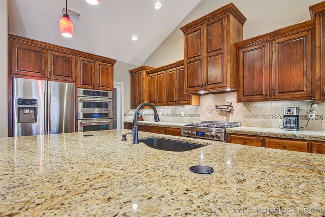 kitchen with decorative backsplash, stainless steel appliances, sink, and hanging light fixtures