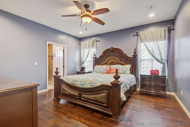 bedroom featuring dark hardwood / wood-style flooring, ceiling fan, and ensuite bathroom