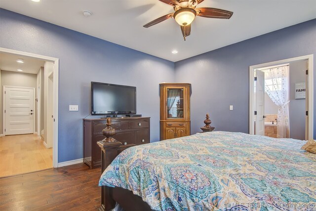 bedroom with ensuite bathroom, dark wood-type flooring, and ceiling fan