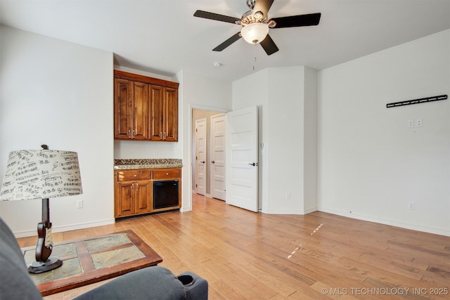 living room with light hardwood / wood-style flooring and ceiling fan