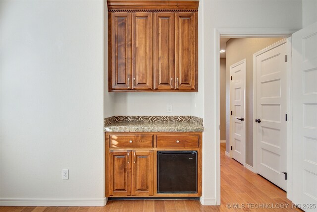 kitchen featuring light stone counters and light wood-type flooring