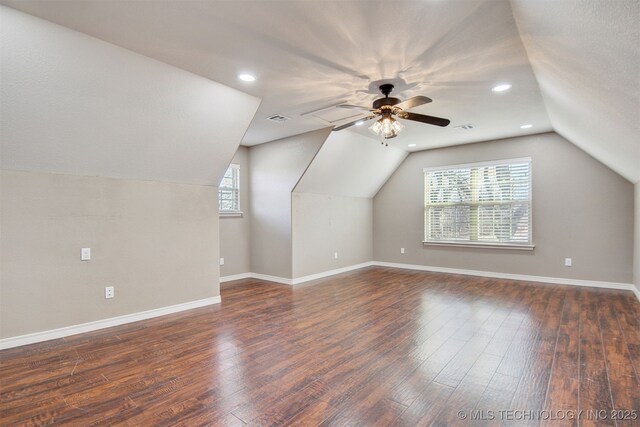 bonus room with vaulted ceiling, plenty of natural light, dark hardwood / wood-style floors, and ceiling fan