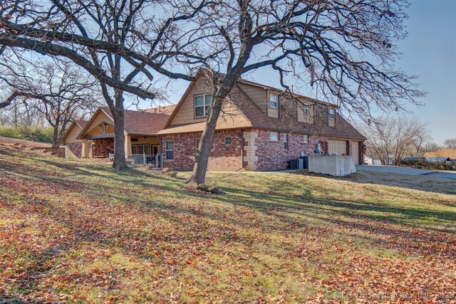 rear view of house featuring a yard and cooling unit