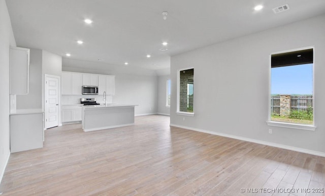 unfurnished living room featuring sink and light wood-type flooring