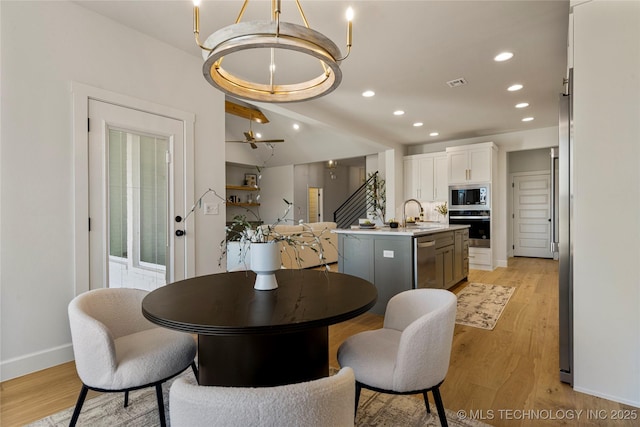 dining room featuring light wood-type flooring and an inviting chandelier