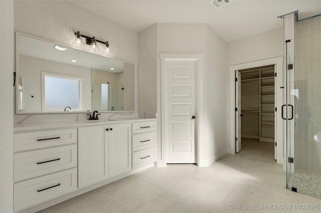 bathroom featuring tile patterned floors, vanity, and a shower with door