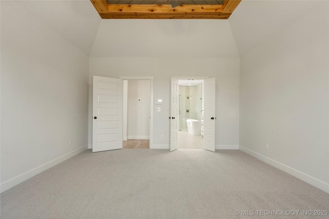 unfurnished bedroom with light carpet, connected bathroom, and high vaulted ceiling