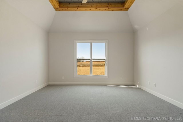 carpeted spare room with vaulted ceiling