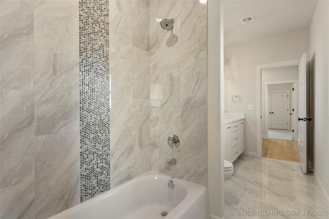 full bathroom featuring vanity, toilet, and tiled shower / bath