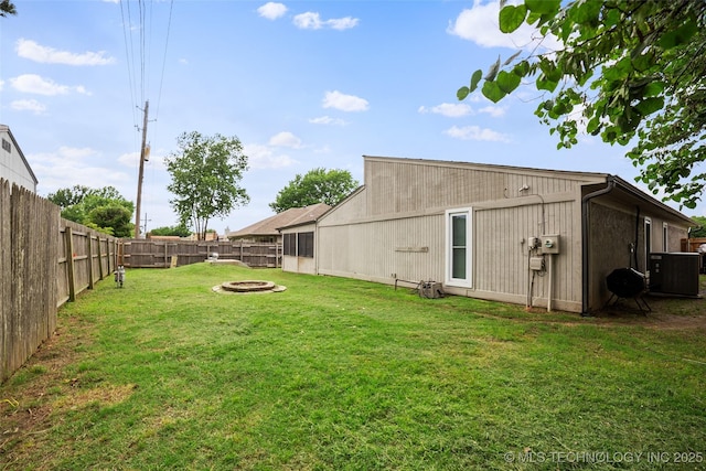 back of property with a yard and a fire pit