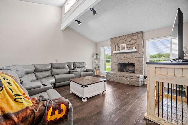 living room with a stone fireplace, dark wood-type flooring, a textured ceiling, and vaulted ceiling with beams