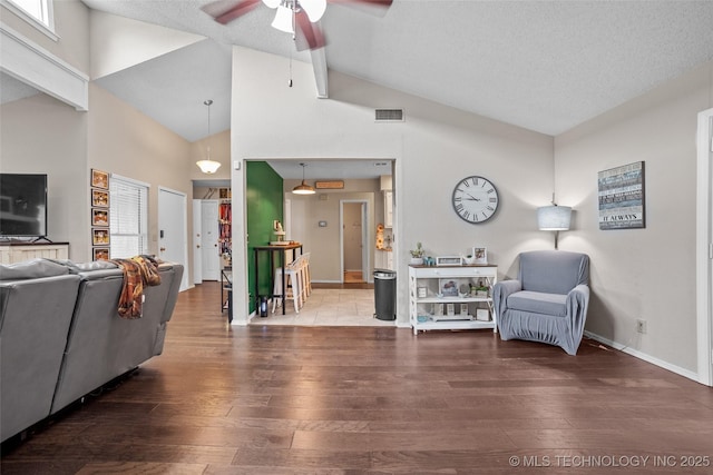 interior space featuring hardwood / wood-style floors, ceiling fan, a textured ceiling, and high vaulted ceiling