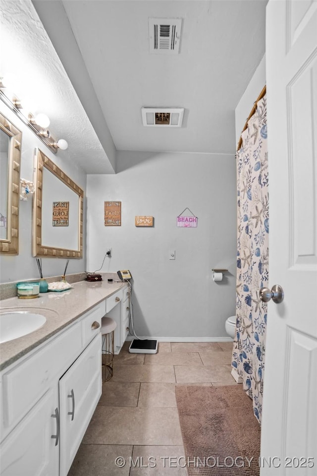 bathroom with tile patterned flooring, vanity, and toilet