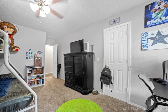 bedroom featuring a textured ceiling, light colored carpet, and ceiling fan