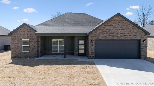 single story home with cooling unit, concrete driveway, an attached garage, a shingled roof, and brick siding