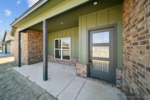 doorway to property with brick siding and board and batten siding