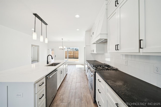 404 W 7th St, Dewey, OK 74029 - kitchen with a sink, tasteful backsplash, wood finished floors, white cabinetry, and appliances with stainless steel finishes