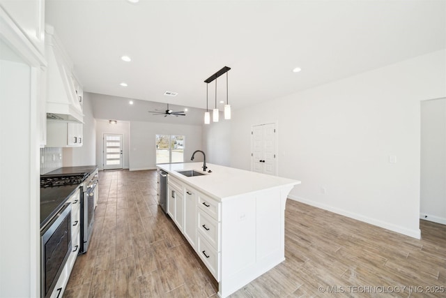 404 W 7th St, Dewey, OK 74029 - kitchen with a sink, appliances with stainless steel finishes, open floor plan, and light wood finished floors
