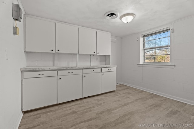 interior space with white cabinets and light wood-type flooring