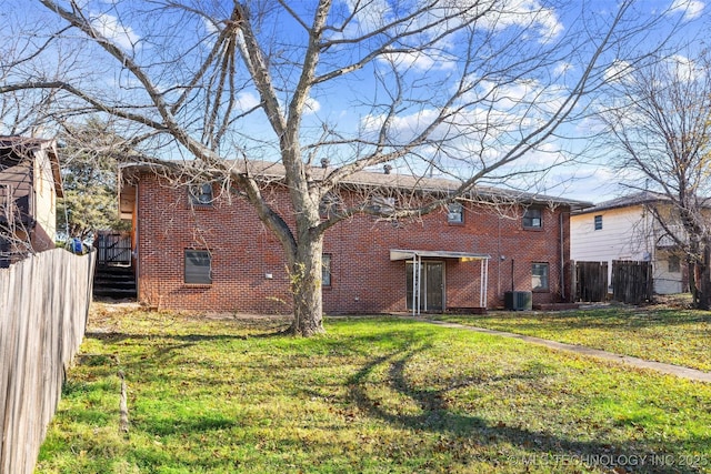 rear view of house with a lawn and central AC unit