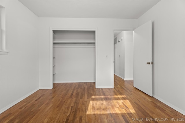 unfurnished bedroom featuring hardwood / wood-style floors and a closet