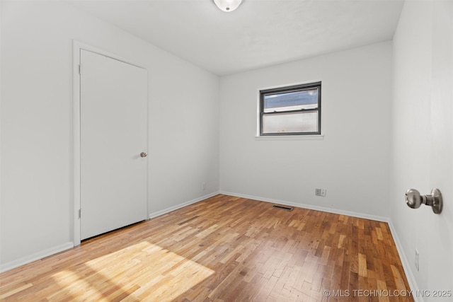 empty room with hardwood / wood-style flooring