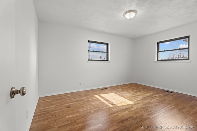 unfurnished room featuring hardwood / wood-style flooring and plenty of natural light