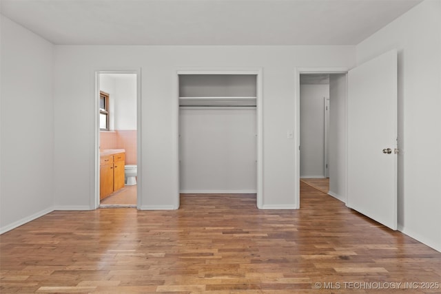 unfurnished bedroom featuring connected bathroom and light hardwood / wood-style floors