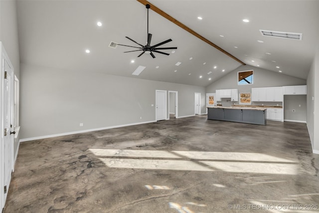 unfurnished living room with beam ceiling, ceiling fan, and high vaulted ceiling