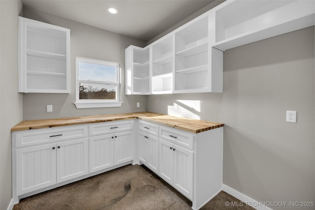 kitchen featuring white cabinetry and wood counters