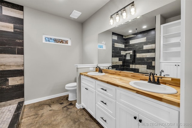 bathroom with concrete flooring, a tile shower, vanity, and toilet